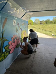 Picture of community mural painting on Fassnight Creek Greenway Trail in September 2023. (Source: Ozark Greenway Facebook page: https://www.facebook.com/media/set/?vanity=OGtrails&set=a.700042362154038)